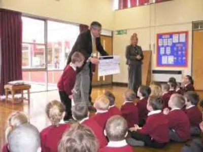 Cllr Brian Gurden presents the cheque to Rucstall pupils