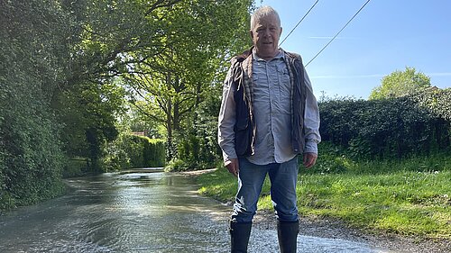 Cllr Kevin Chatburn standing on a flooded road